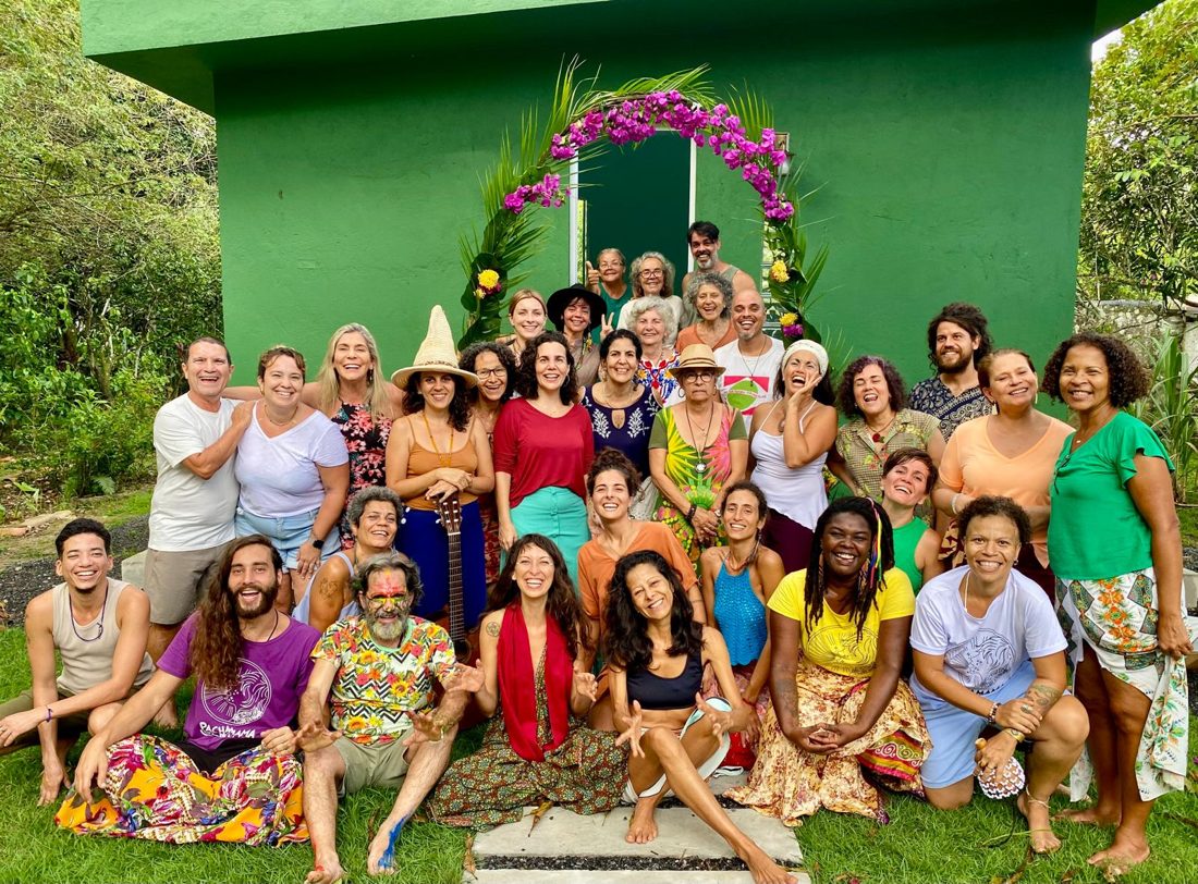 Grande grupo de moradores e visitantes reunido em um espaço comunitário verde